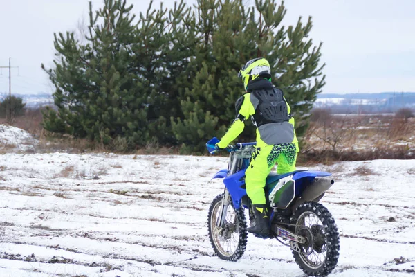 Bir adam bir çapraz-motosiklet trenlerde kar kış.