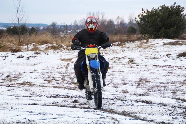Bir adam bir çapraz-motosiklet trenlerde kar kış.