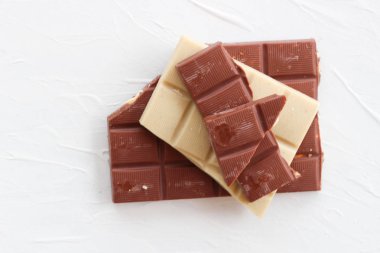 Beyaz ve sütlü çikolata. Fayans çikolata beyaz bir arka plan üzerinde.