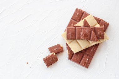 Beyaz ve sütlü çikolata. Fayans çikolata beyaz bir arka plan üzerinde.