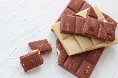 Beyaz ve sütlü çikolata. Fayans çikolata beyaz bir arka plan üzerinde.