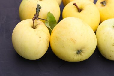 Sonbaharda hasat düzeni. Siyah bir zemin üzerine sarı elmalar.