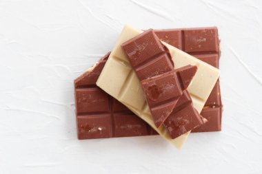 Beyaz ve sütlü çikolata. Fayans çikolata beyaz bir arka plan üzerinde.