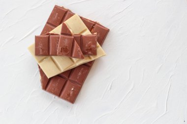 Beyaz ve sütlü çikolata. Fayans çikolata beyaz bir arka plan üzerinde.