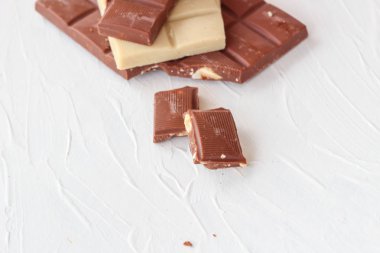 Beyaz ve sütlü çikolata. Fayans çikolata beyaz bir arka plan üzerinde.