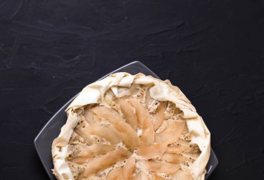 Elma pasta karanlık bir arka plan üzerine badem krema ile. Pişmiş kek. Güveç pişmiş multivarts doğru beslenme içinde. Güneşli bir günde tüm aile için pasta.