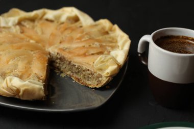 Elma pasta karanlık bir arka plan üzerine badem krema ile. Kahve ve çay kaşığı pişmiş pasta. Güneşli bir günde tüm aile için pasta.