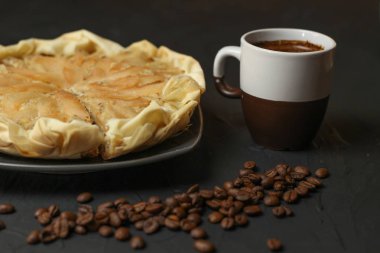 Elma pasta karanlık bir arka plan üzerine badem krema ile. Kahve ve çay kaşığı pişmiş pasta. Güneşli bir günde tüm aile için pasta.