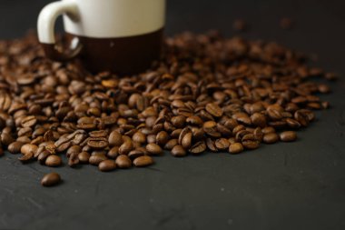 Bir fincan kahve kahve çekirdekleri karanlık bir arka plan ile. Lezzetli kokulu kahve en iyi çeşitleri.