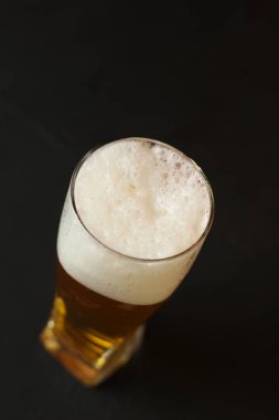 Siyah bir arka plan üzerinde bir cam kasede Light bira. Barda bira.