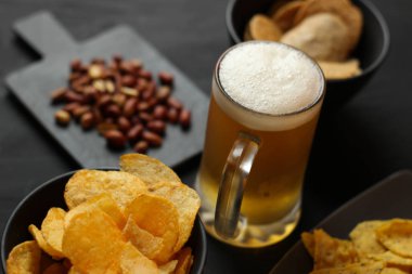 Siyah bir arka plan üzerinde bir cam kasede Light bira. Bira bar ve aperatifler, cips, Kuruyemiş.