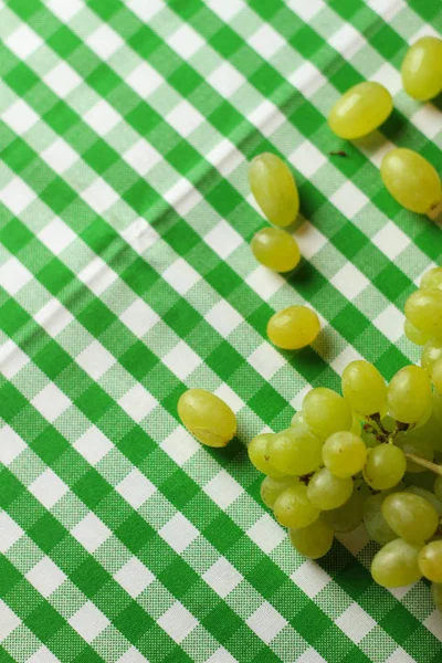 Fruit placement on white green cloth,with green grapes. Home table.