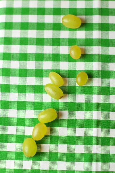 Fruit placement on white green cloth,with green grapes. Home table.