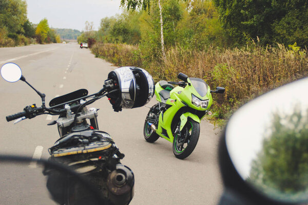 Green sport motorbike with racer on the background of gray asphalt. Ukraine, Lviv.