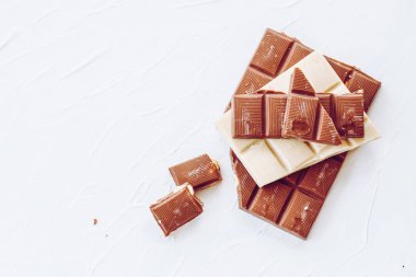 Beyaz ve sütlü çikolata. Fayans çikolata beyaz bir arka plan üzerinde.