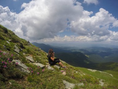 Yaz yeşil Karpatlar Ukrayna. Dağların üzerinden gökyüzüdür. Bir cip üzerinde seyahat ederken atmosferik manzaralar. Offroad seferi. Çiçekli kız