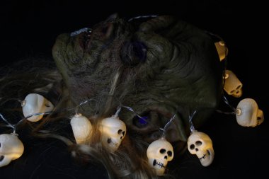 Cadılar Bayramı halloween süslemeleri ile yakında sonbahar kompozisyon. Kafatası, garland, kabak, troll maskesi.