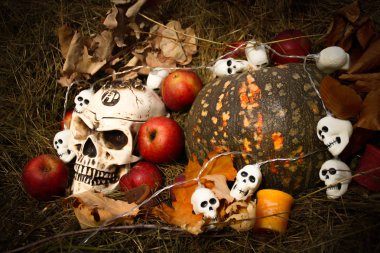 Cadılar Bayramı halloween süslemeleri ile yakında sonbahar kompozisyon. Kafatası, garland, balkabağı. Saman backgtound.