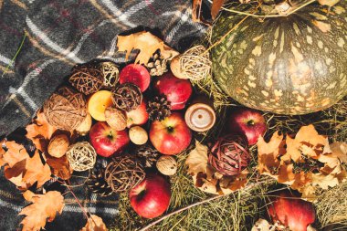 Sonbahar kompozisyon. Elma, kabak, düşen yapraklar ve mumlar saman bir zemin üzerine düzeni.