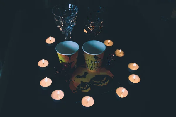 Halloween soon Autumn composition with halloween decorations. Goblet, paper glass,candles, skull garland