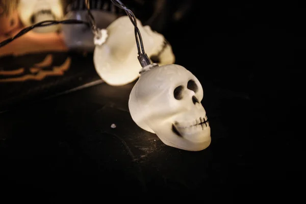 Halloween soon Autumn composition with halloween decorations. Goblet, paper glass,candles, skull garland