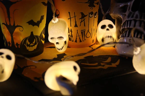 Halloween soon Autumn composition with halloween decorations. Goblet, paper glass,candles, skull garland