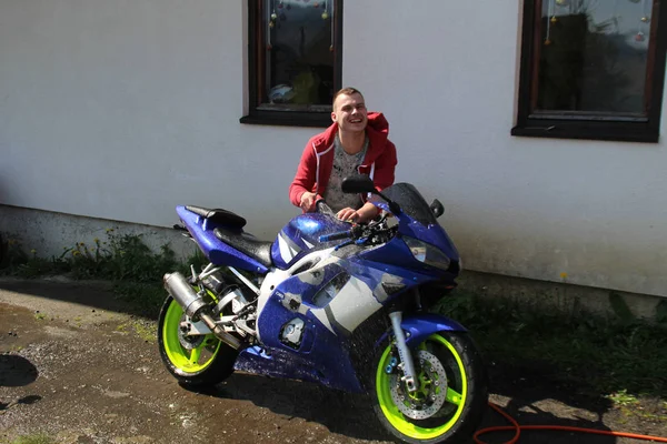 スポーツ バイクは家の近くです 若い男は 彼のバイクを洗います 家庭洗濯 — ストック写真