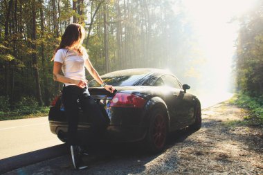 Sonbahar ormandaki güzel siyah araba. Audi tt kırmızı diskler ile. Açık photoshoot beyaz t-shirt ve koyu mavi jeans Kızıl saçlı grazy kızla. Ekim 2018, Lviv Ukrayna.