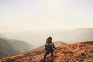 Mavi kazaklı bir desen ile bir kız. Ukrayna Karpatlar Güz. Sıcak renkli yeşil yaprakları. macera gerçek sayısı ruhu. Ormanlar ve dağlar.