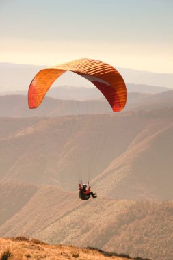 Yamaç paraşütü Ukraynalı Karpatlar içinde. Paraşüt dağlar insanlar. Güneşli bir sonbahar manzaraları. Yamaç paraşütü için donatılması. Sportsmen.Sunsut ve gündoğumu.