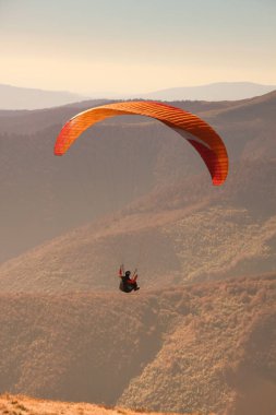 Yamaç paraşütü Ukraynalı Karpatlar içinde. Paraşüt dağlar insanlar. Güneşli bir sonbahar manzaraları. Yamaç paraşütü için donatılması. Sportsmen.Sunsut ve gündoğumu.