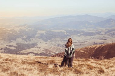 Yeşil desen çalma husky ile otantik bir panço bir kız. Sonbahar zaman içinde Ukrayna Karpatlar. Sıcak renkli yeşil yaprakları. Ormanlar ve dağlar üst görünümden. Köpekle seyahat