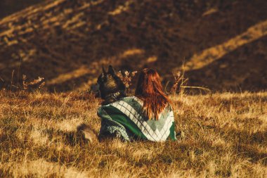 Yeşil desen çalma husky ile otantik bir panço bir kız. Sonbahar zaman içinde Ukrayna Karpatlar. Sıcak renkli yeşil yaprakları. Ormanlar ve dağlar üst görünümden. Köpekle seyahat
