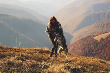 Yeşil desen çalma husky ile otantik bir panço bir kız. Sonbahar zaman içinde Ukrayna Karpatlar. Sıcak renkli yeşil yaprakları. Ormanlar ve dağlar üst görünümden. Köpekle seyahat