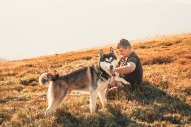 Siyahlı adam t-shirt Dağı top oynamak ile iki dış yapraklar. Sonbahar zaman içinde Ukrayna Karpatlar. Sıcak renkli yeşil yaprakları. Ormanlar ve dağlar görüntüleyin. Köpekle seyahat