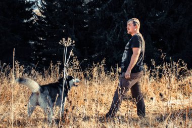 Siyah t-shirt erkekte oyun alanında funny dış yapraklar ile. Sonbahar zaman içinde Ukrayna Karpatlar. Sıcak renkli yeşil yaprakları. Ormanlar ve dağlar görüntüleyin. Köpekle seyahat