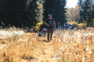 Siyah t-shirt erkekte oyun alanında funny dış yapraklar ile. Sonbahar zaman içinde Ukrayna Karpatlar. Sıcak renkli yeşil yaprakları. Ormanlar ve dağlar görüntüleyin. Köpekle seyahat