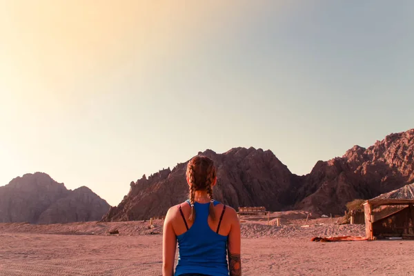 Desert in Egypt. Sharm el Sheikh. Sand and Sand Borkhan. Rock and sunset. Quad Cycle Travel. Excursion with people.Girl in blue t-shirt and shorts.