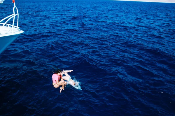 两个女孩从游艇的鼻子里跳水 红海沙姆沙伊赫 乘船旅行 疯狂的女人 — 图库照片