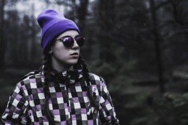 Esmer mor şapka, gözlük ve balta. Ormanda portreler. Kayak ceketi giyen dağ fotoğraf. Koyu arka plan. Ukraynalı Karpat Dağları. Gezgin