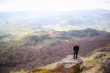 Kız dağ manzaralı bir uçurumun kenarında oturur. Ukraynalı Karpat Dağları. Seyahat