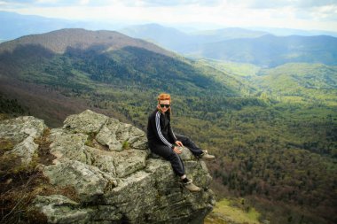 Kız dağ manzaralı bir uçurumun kenarında oturur. Ukraynalı Karpat Dağları. Seyahat