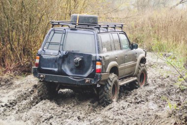 Offroad araba büyük bataklıklar ile çalışır. Shrazjuk yağmur sonra. Zor yol. Kanlı kirli tekerlekler.