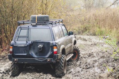 Offroad araba büyük bataklıklar ile çalışır. Shrazjuk yağmur sonra. Zor yol. Kanlı kirli tekerlekler.