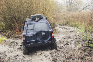 Offroad araba büyük bataklıklar ile çalışır. Shrazjuk yağmur sonra. Zor yol. Kanlı kirli tekerlekler.