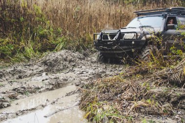Offroad araba büyük bataklıklar ile çalışır. Shrazjuk yağmur sonra. Zor yol. Kanlı kirli tekerlekler.