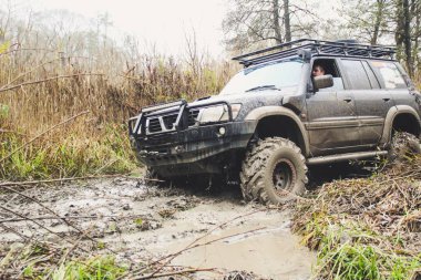 Offroad araba büyük bataklıklar ile çalışır. Shrazjuk yağmur sonra. Zor yol. Kanlı kirli tekerlekler.