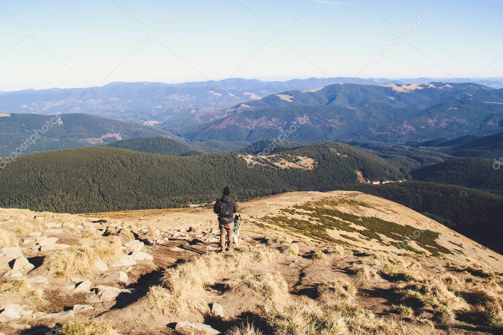 The boy travels with husky. Ukrainian Carpathian Mountains. Top of the mountain.  Black and white dog. Hiking with dog