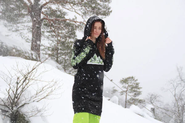 Kış orman. Bir kayaya kızdır. Siyah uzun sıska Kayak yeşil pantolon. Düşen kar Dovbush kayalar, Ukrayna