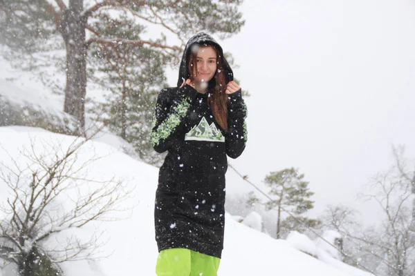 Kış orman. Bir kayaya kızdır. Siyah uzun sıska Kayak yeşil pantolon. Düşen kar Dovbush kayalar, Ukrayna